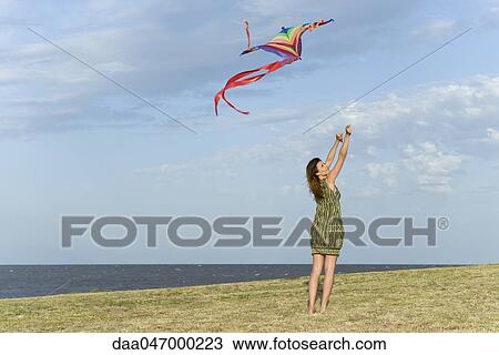 Woman flying kite View Large Photo Image Stock Image - Woman flying kite. Fotosearch