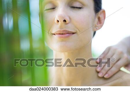 Woman having massage, smiling, bamboo in blurred foreground View Large Photo Image Stock Image - Woman having massage, smiling, bamboo in blurred foreground. Fotosearch