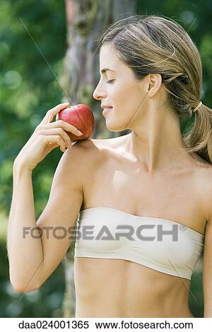 Woman holding apple on shoulder View Large Photo Image Stock Photography - Woman holding apple on shoulder. Fotosearch