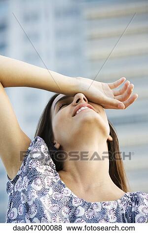 Woman holding back of hand over eye, head back View Large Photo Image Stock Photo - Woman holding back of hand over eye, head back. Fotosearch