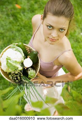 Woman holding basket of fresh vegetables, high angle view View Large Photo Image Stock Image - Woman holding basket of fresh vegetables, high angle view. Fotosearch