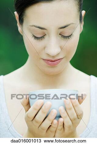 Stock Image - Woman holding bowl cupped in hands. Fotosearch