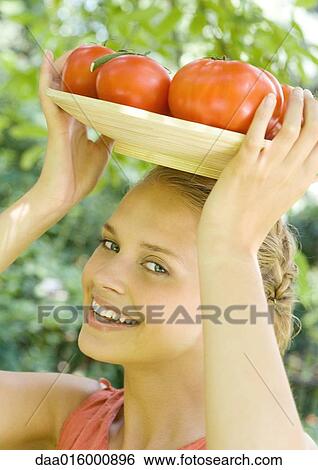 Woman holding bowl full of tomatoes on top of head View Large Photo Image Stock Photograph - Woman holding bowl full of tomatoes on top of head. Fotosearch