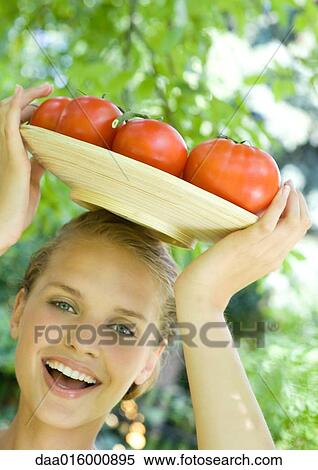 Woman holding bowl full of tomatoes on top of head View Large Photo Image Stock Photography - Woman holding bowl full of tomatoes on top of head. Fotosearch