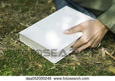 Woman holding closed book, marking place with finger View Large Photo Image Stock Photo - Woman holding closed book, marking place with finger. Fotosearch