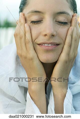 Woman holding face in hands, smiling, eyes closed, close-up View Large Photo Image Stock Image - Woman holding face in hands, smiling, eyes closed, close-up. Fotosearch