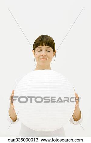 Woman holding large sphere, eyes closed View Large Photo Image Stock Image - Woman holding large sphere, eyes closed. Fotosearch
