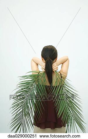 Woman holding palm leaves behind back, rear view View Large Photo Image Stock Image - Woman holding palm leaves behind back, rear view. Fotosearch