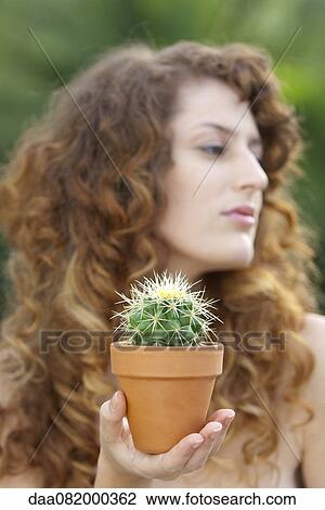 Woman holding potted cactus in palm, looking away View Large Photo Image Stock Image - Woman holding potted cactus in palm, looking away. Fotosearch