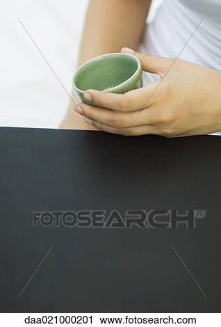 Woman holding tea cup, cropped view View Large Photo Image Stock Image - Woman holding tea cup, cropped view. Fotosearch