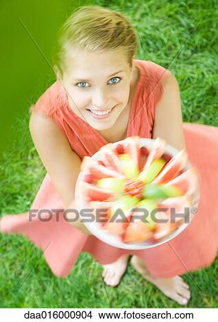 Woman holding up plate full of fruit slices and spinning around, high angle view View Large Photo Image Picture - Woman holding up plate full of fruit slices and spinning around, high angle view. Fotosearch