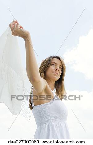 Woman holding up shawl outdoors, smiling, low angle view View Large Photo Image Stock Image - Woman holding up shawl outdoors, smiling, low angle view. Fotosearch