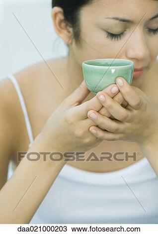 Woman holding up tea cup, eyes closed View Large Photo Image Stock Image - Woman holding up tea cup, eyes closed. Fotosearch