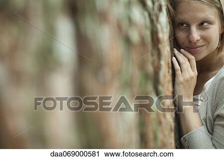 Stock Image - Woman hugging tree, portrait. Fotosearch