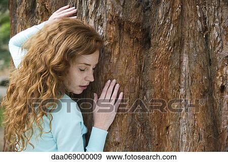 Stock Photo - Woman hugging tree. Fotosearch