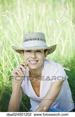 Woman in field, blade of grass between lips, looking at camera View Large Photo Image Stock Image - Woman in field, blade of grass between lips, looking at camera. Fotosearch