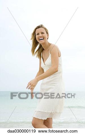 Woman in sundress at the beach, smiling, laughing View Large Photo Image Stock Photo - Woman in sundress at the beach, smiling, laughing. Fotosearch