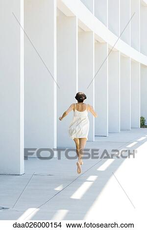Woman in sundress running outdoors, rear view View Large Photo Image Picture - Woman in sundress running outdoors, rear view. Fotosearch