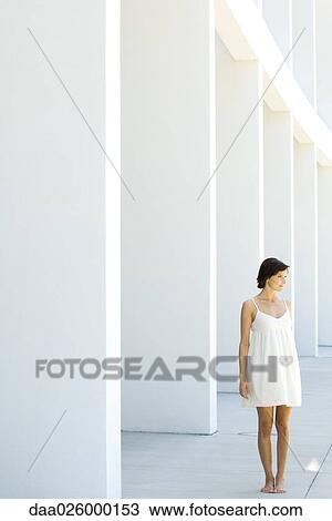 Woman in sundress standing outdoors in front of modern colonnade View Large Photo Image Stock Image - Woman in sundress standing outdoors in front of modern colonnade. Fotosearch