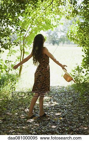 Woman in woods with arms outstretched, rear view View Large Photo Image Stock Photography - Woman in woods with arms outstretched, rear view. Fotosearch