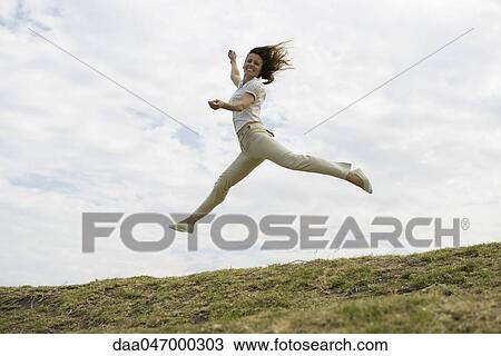 Stock Image - Woman jumping, midair. Fotosearch