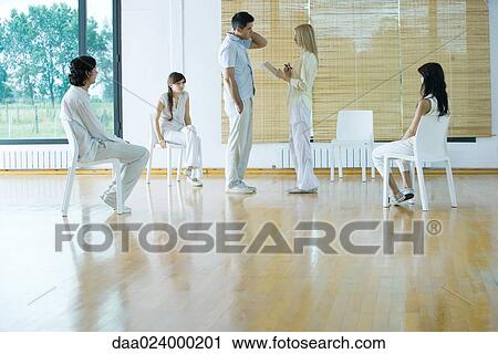 Woman leading group therapy session, holding notebook, speaking to man View Large Photo Image Stock Image - Woman leading group therapy session, holding notebook, speaking to man. Fotosearch
