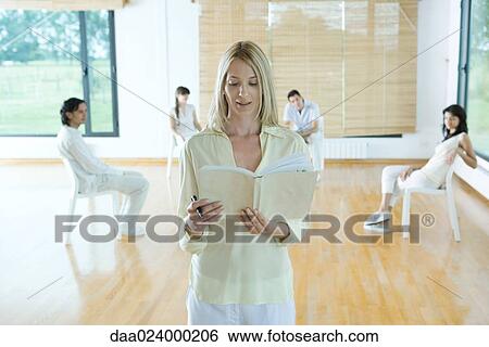 Woman leading group therapy session, reading from book, facing camera View Large Photo Image Stock Photograph - Woman leading group therapy session, reading from book, facing camera. Fotosearch