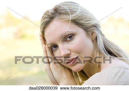 Woman leaning against clasped hands, looking at camera View Large Photo Image Stock Photo - Woman leaning against clasped hands, looking at camera. Fotosearch