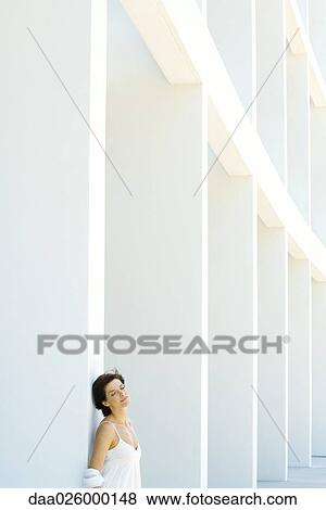 Woman leaning against column, eyes closed, hair tousled by breeze View Large Photo Image Stock Photo - Woman leaning against column, eyes closed, hair tousled by breeze. Fotosearch