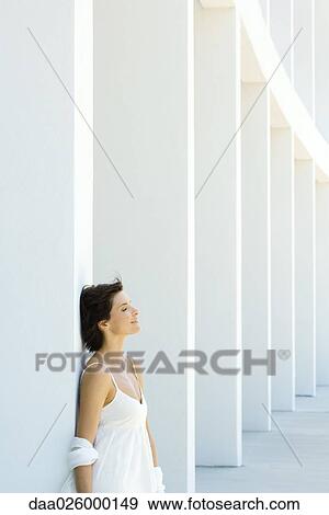 Woman leaning against column, eyes closed, hair tousled by breeze View Large Photo Image Stock Photo - Woman leaning against column, eyes closed, hair tousled by breeze. Fotosearch
