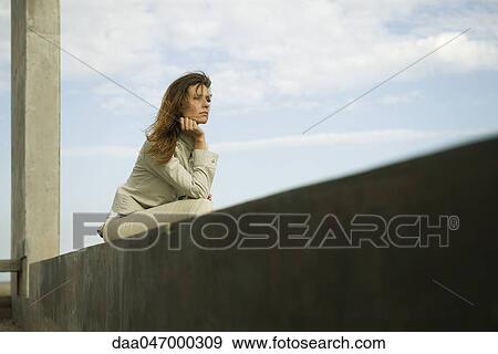 Woman leaning on elbow contemplatively looking away View Large Photo Image Stock Photo - Woman leaning on elbow contemplatively looking away. Fotosearch
