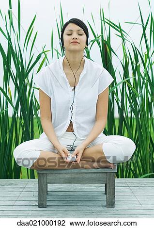 Stock Image - Woman listening to headphones, eyes closed. Fotosearch