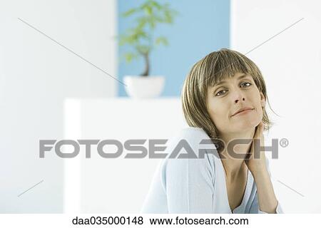 Woman looking at camera, holding neck, portrait View Large Photo Image Stock Photo - Woman looking at camera, holding neck, portrait. Fotosearch