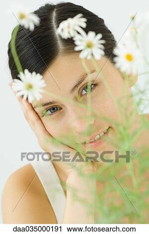 Woman looking at camera through leaves of chamomile plant View Large Photo Image Stock Image - Woman looking at camera through leaves of chamomile plant. Fotosearch