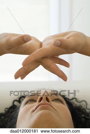 Stock Image - Woman looking at her clasped hands, close-up. Fotosearch