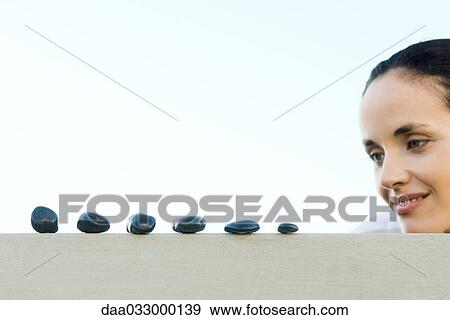Woman looking at line of stones View Large Photo Image Stock Photo - Woman looking at line of stones. Fotosearch