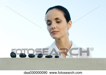 Woman looking at row of stones, low angle view View Large Photo Image Stock Image - Woman looking at row of stones, low angle view. Fotosearch