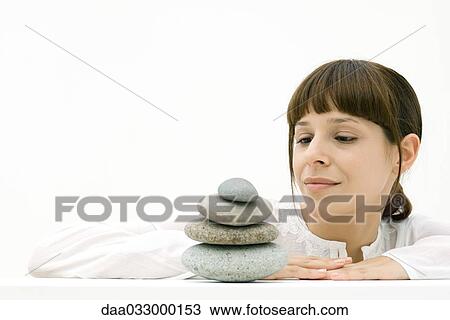 Woman looking at stacked stones, smiling View Large Photo Image Stock Image - Woman looking at stacked stones, smiling. Fotosearch