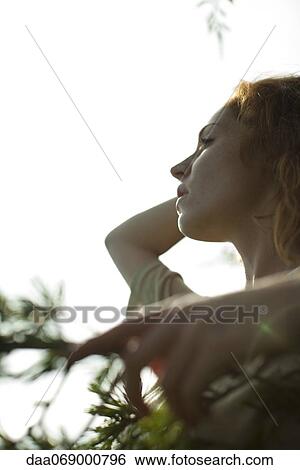 Stock Photograph - Woman looking away dreamily, portrait. Fotosearch