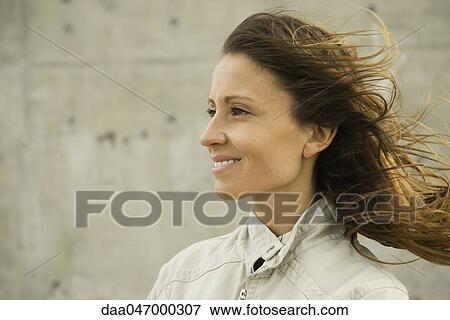 Woman looking away, hair tousled by breeze, portrait View Large Photo Image Stock Photo - Woman looking away, hair tousled by breeze, portrait. Fotosearch