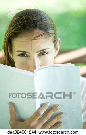 Woman looking over book View Large Photo Image Picture - Woman looking over book. Fotosearch