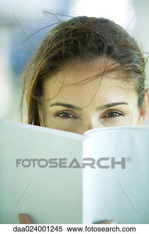 Woman looking over book View Large Photo Image Stock Photography - Woman looking over book. Fotosearch