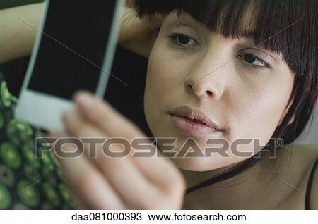 Woman looking sadly at photograph View Large Photo Image Stock Image - Woman looking sadly at photograph. Fotosearch