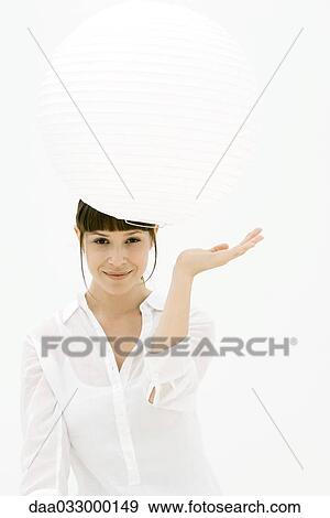 Woman looking underneath paper lantern, smiling at camera View Large Photo Image Stock Photo - Woman looking underneath paper lantern, smiling at camera. Fotosearch