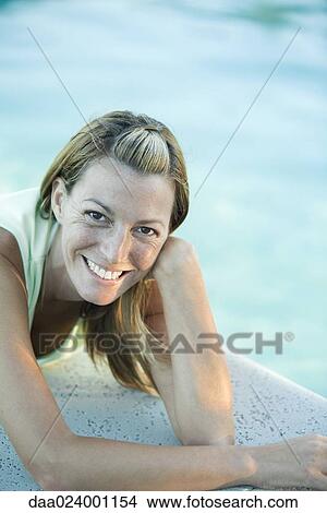 Woman lying by edge of pool, smiling at camera View Large Photo Image Picture - Woman lying by edge of pool, smiling at camera. Fotosearch