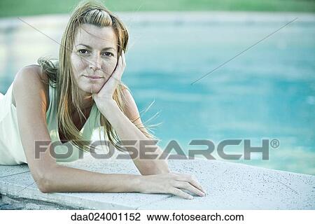 Woman lying by edge of pool View Large Photo Image Stock Image - Woman lying by edge of pool. Fotosearch