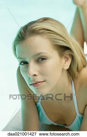 Woman lying by pool, looking at camera, portrait View Large Photo Image Stock Photo - Woman lying by pool, looking at camera, portrait. Fotosearch