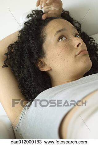 Stock Image - Woman lying down, looking up. Fotosearch