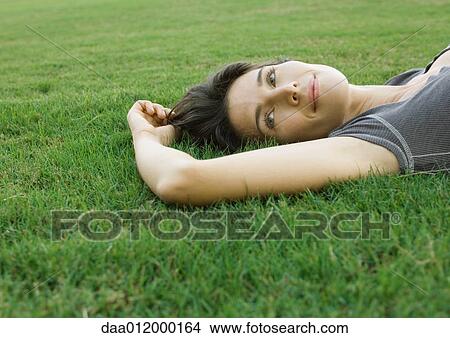 Picture - Woman lying in grass. Fotosearch