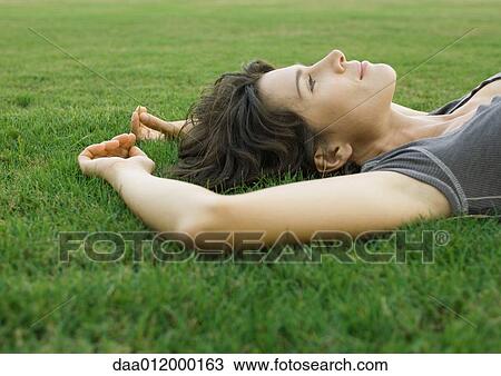 Stock Image - Woman lying in grass. Fotosearch